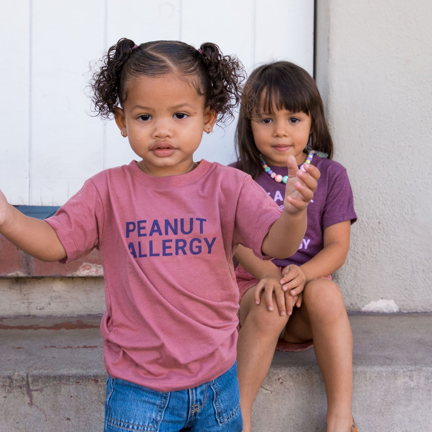 girl in mauve t-shirt with peanut allergy text
