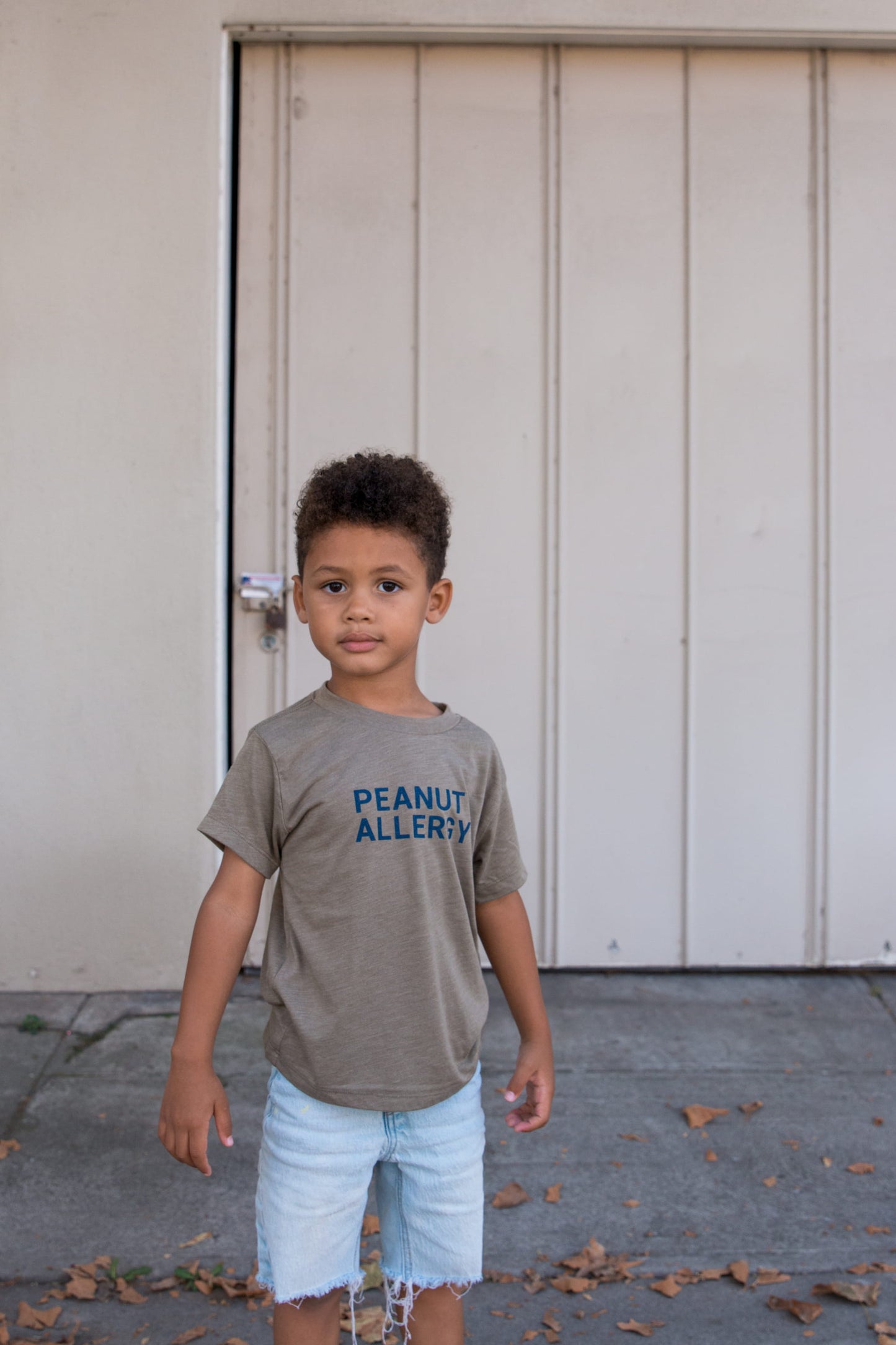 boy in olive t-shirt with peanut allergy text